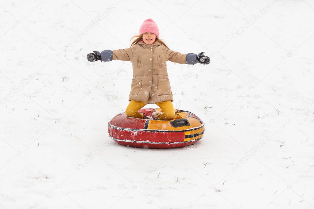Picture of happy girl riding tubing in winter park