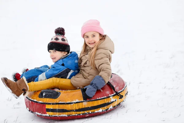 Bild av glada flicka och pojke som rider på slangen — Stockfoto