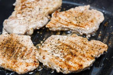 Tırtıllı kalbur üzerinde kavrulmuş et parçaları