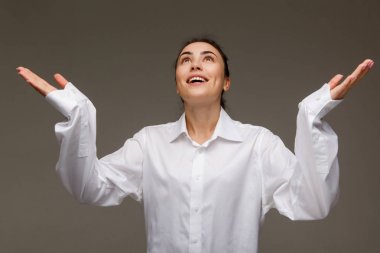 Güzel kız Beyaz gömlekli duygular gösterir - umuyoruz. Hafif bir arka plan üzerinde.