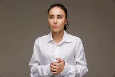 Beyaz bir gömlek güzel kızı duygu - düşünce gösterir. Hafif bir arka plan üzerinde.