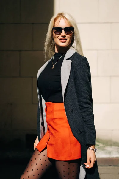 Chica de moda en ropa de moda. Hermosa chica con un abrigo y una falda roja. Posando en la calle —  Fotos de Stock