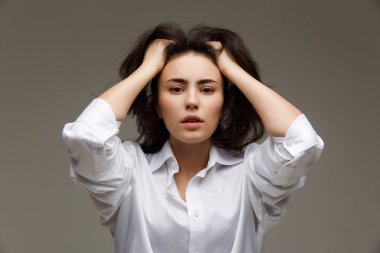 Beyaz bir gömlek güzel kızı duygu - düşünce gösterir. Hafif bir arka plan üzerinde.