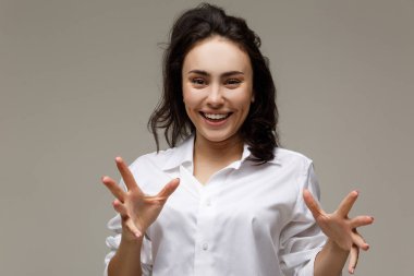 Güzel kız Beyaz gömlekli duygular - sürpriz, şok, hafif bir arka plan üzerinde gösterir..