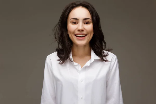 Красивая девушка в белой рубашке показывает эмоции - улыбка, веселье . — стоковое фото