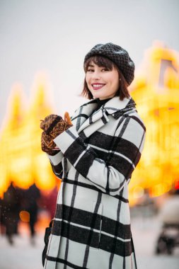 Kış yürüyüşünde şapkalı ve paltolu genç esmerin portresi..