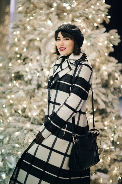 Foto von glücklichen Brünette in der Nähe von weißen künstlichen Weihnachtsbaum auf Spaziergang — Stockfoto
