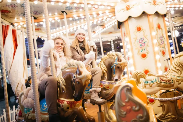 Photo of two women riding on carousel in park — Stock Photo, Image