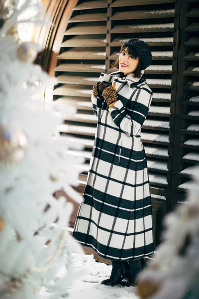 Foto von glücklichen Brünette in der Nähe von weißen künstlichen Weihnachtsbaum für Spaziergang auf der Straße — Stockfoto