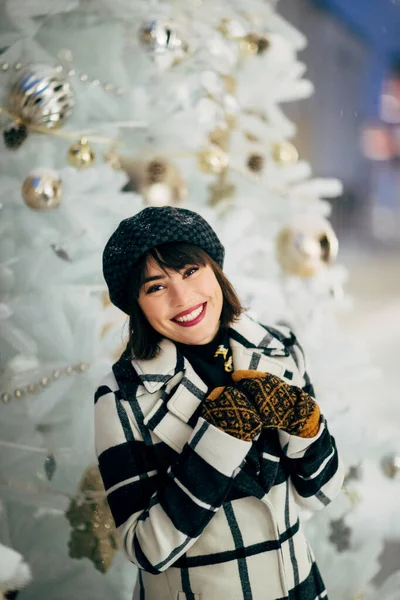 Bild von glücklichen Mädchen in der Nähe von weißen künstlichen Weihnachtsbaum auf Spaziergang an der Straße — Stockfoto