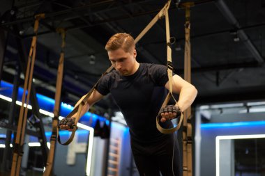 Lastik bantlar üzerinde egzersiz yapan atletik bir adam.