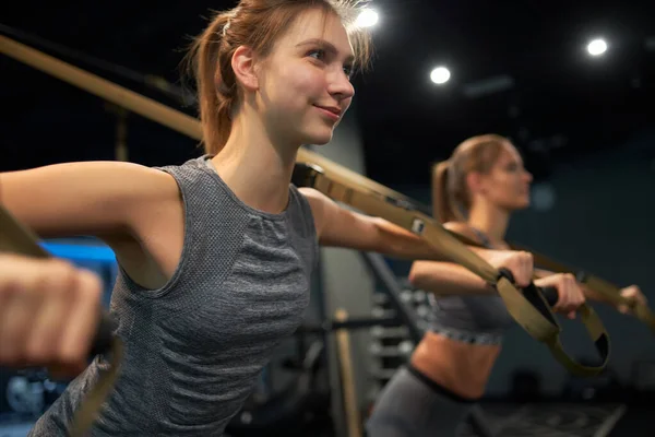 Two happy athletic girls in training with elastic bands — Stockfoto