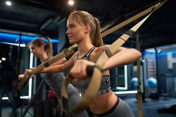 Две атлетичные женщины на тренировках с эластичными лентами — стоковое фото