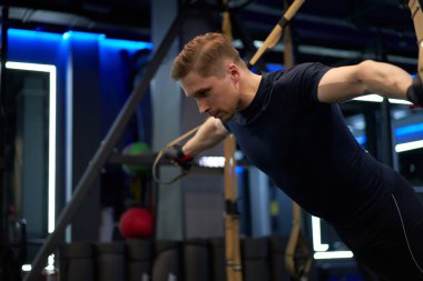 Lastik bantlar üzerinde egzersiz yapan ciddi bir sporcu.