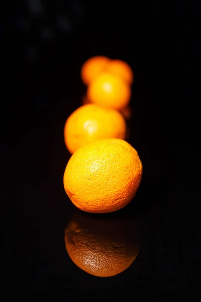 Wenige Orangen auf schwarzem Hintergrund — Stockfoto