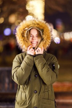 Bulanık arkaplanda ceketli genç bir sarışın.