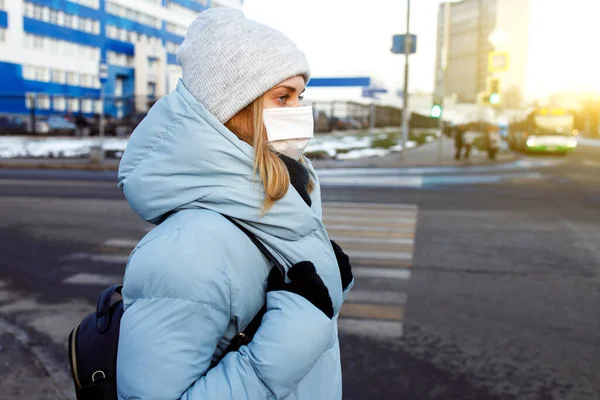 Молода жінка в масці на прогулянці по вулиці в місті вдень . — стокове фото