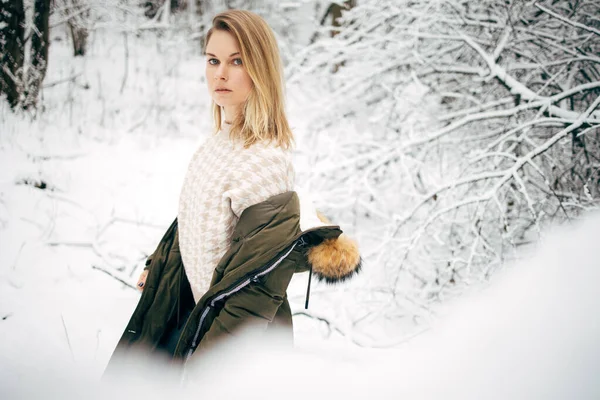 Blond på bakgrund av snöiga träd för promenad i vinterskogen på eftermiddagen — Stockfoto