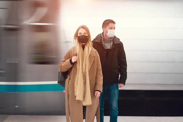 Чоловік і жінка в медичних масках, що стоять біля машини в метро . — стокове фото