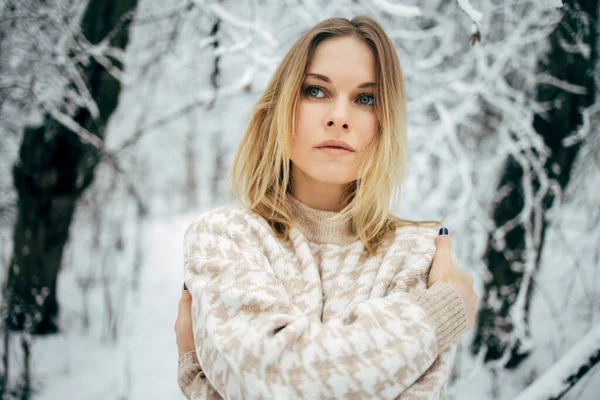 Mujer joven mirando al lado en el fondo de los árboles nevados para caminar en el bosque de invierno — Foto de Stock