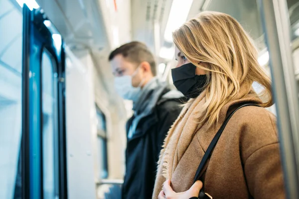 Вид сбоку на мужчину и женщину, стоящих в вагоне метро . — стоковое фото