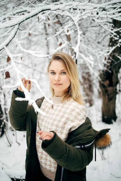 Счастливая блондинка на фоне снежных деревьев для прогулки в зимнем лесу — стоковое фото