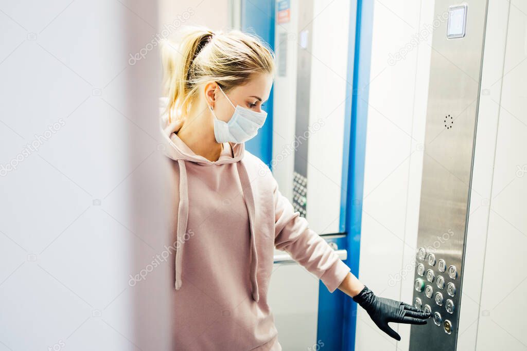 woman with gloves calls the elevator