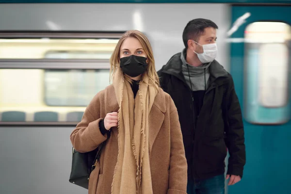地下鉄の車の近くに立っている医療マスクの若い男と女. — ストック写真
