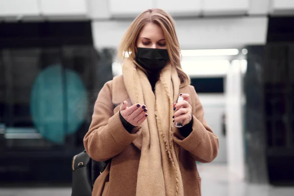 医療マスクの女性の閉鎖は地下鉄で手を消毒します。コロナウイルスの流行 — ストック写真