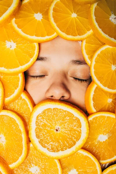 Обличчя красивої людини в апельсинових скибочках — стокове фото