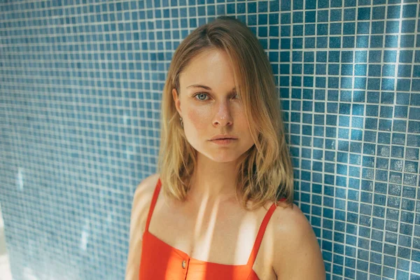 Mujer en vestido rojo en el fondo de la pared de mosaico azul — Foto de Stock