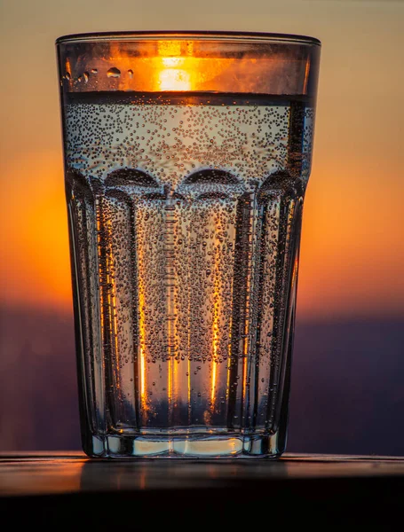 Un verre d'eau pétillante au coucher du soleil. Soirée d'été — Photo