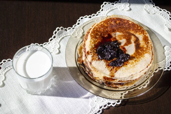 Fresh pancakes with jam and a glass of milk. — Stock Photo, Image