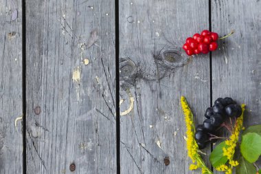 Eski ahşap arka planda böğürtlen ve çiçek kasesi. Seçici odaklanma. Metin için boşluk.