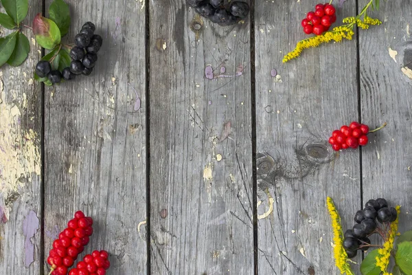 Top view bowl of berries and flowers on old wooden background. Selective focus. Space for text. — Stock Photo, Image