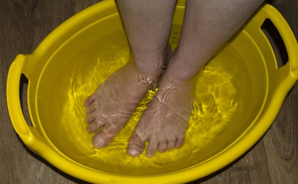 Frauen weichen Füße in der Wanne ein, um sich zu entspannen und bereit für das Nägelschneiden. — Stockfoto