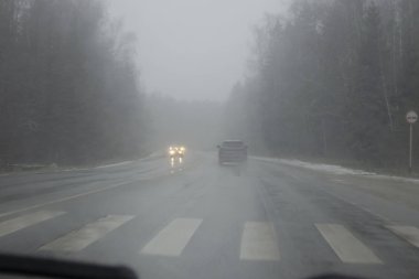 Kar fırtınası sırasında karlı kış yolu. Şiddetli kar fırtınası.