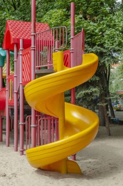 Sağ tarafta spiral kaydıraklı çocuk oyunu kompleksi