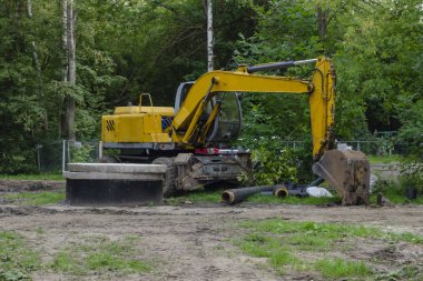 Sarı Kazı Makinesi yığının yanında duruyor.
