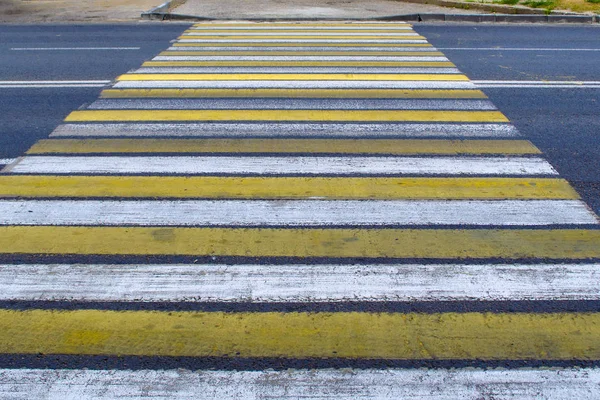 Crosswalk e ponto de passagem pedestre perspectiva na estrada da cidade chuvosa, rua ou avenida forrada com linhas de zebra amarelas e brancas no dia de verão — Fotografia de Stock