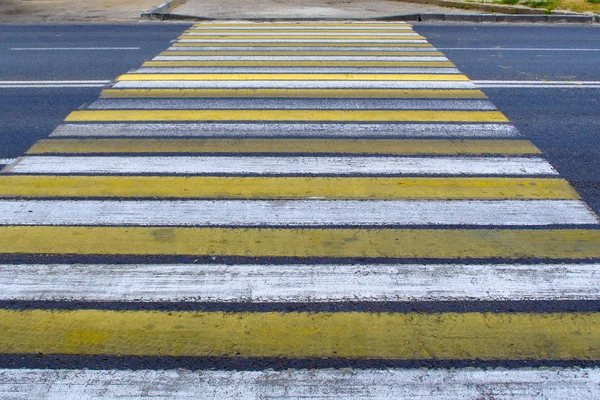 Yaya geçidi ve yaya geçidi manzaralı yağmurlu şehir yolu, sokak ya da cadde yaz günü sarı ve beyaz zebra çizgileri ile kaplı.