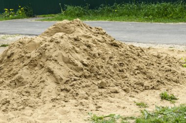 Küçük nehir kumu dağı inşaat için yola dökülüyor.