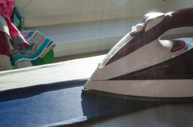 Ütü ve giysiler evdeki masada.