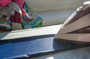 Ütü ve giysiler evdeki masada.