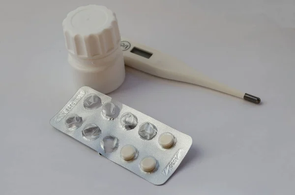 Termómetro de la lata del fármaco y placa comenzada con tabletas — Foto de Stock