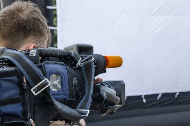 Kameraman, canlı yayında caddedeki olayları filme alır.