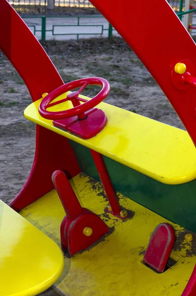 Coche de juguete de madera en el patio de recreo para niños. Volante de metal rojo del coche de madera para niños en el patio de recreo . — Foto de Stock