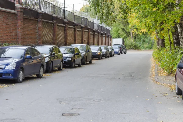 Arabalar yol boyunca park halinde. Otoparktaki Arabalar