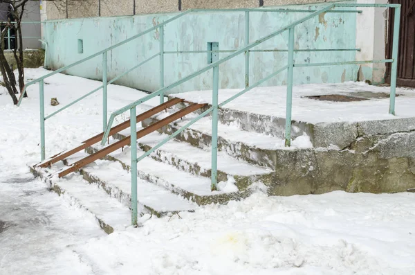 Rampa para la silla de ruedas y escaleras para personas normales contiguas, nieve Imágenes de stock libres de derechos