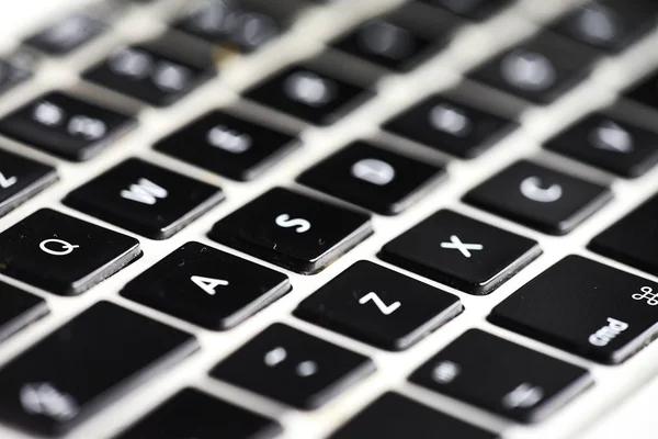 Perspectiva do teclado de um laptop em preto e branco borrão — Fotografia de Stock